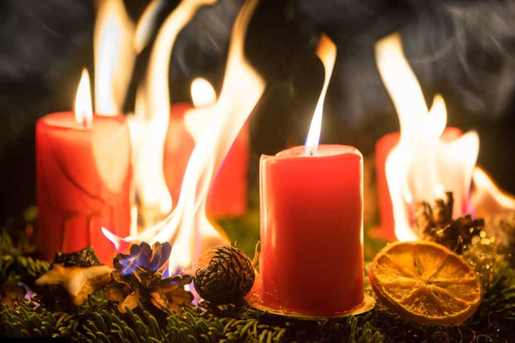 Ein Adventskranz mit roten Kerzen geht in Flammen auf.