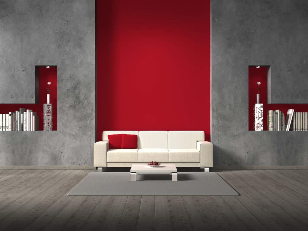 Besondere Wandgestaltung: Ein weißes Sofa und ein weißer Couchtisch vor einer Wand aus Beton und rot akzentuierten Aussparungen sind sehr modern.