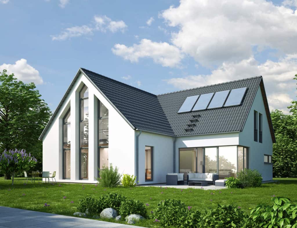 Ein modernes weißes Haus mit großen Fenstern, Garten und Solaranlage auf dem Dach.