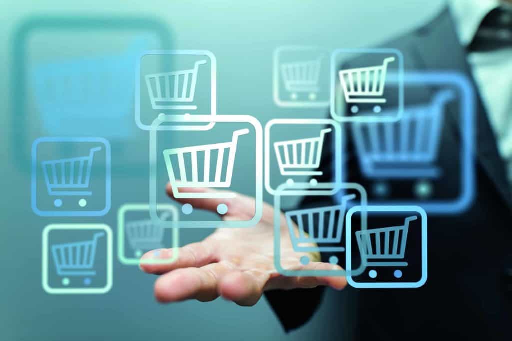 Grafik zum E-Commerce-Kaufmann: Hand umgeben von schwebenden Einkaufswagen-icons