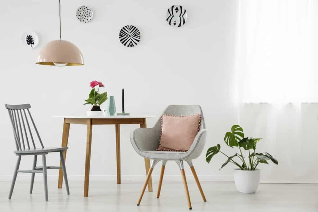 Graue Stühle, Holztisch und Pflanze, Wandteller (langweilige Wände)