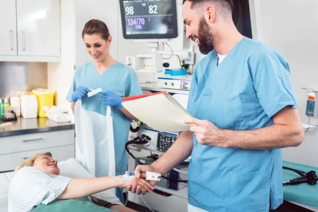 Arzt und Pflegerin begrüßen Patientin im Krankenhaus – Pflegekräfte in der Zeitarbeit