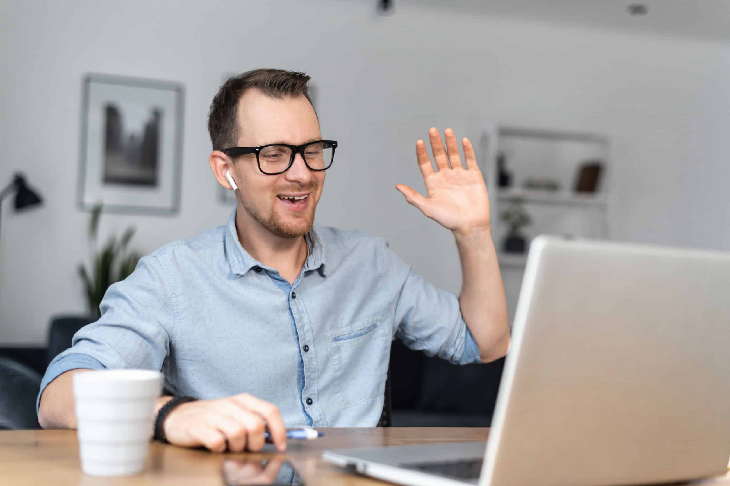 Ein Mann der jemanden am PC begrüßt