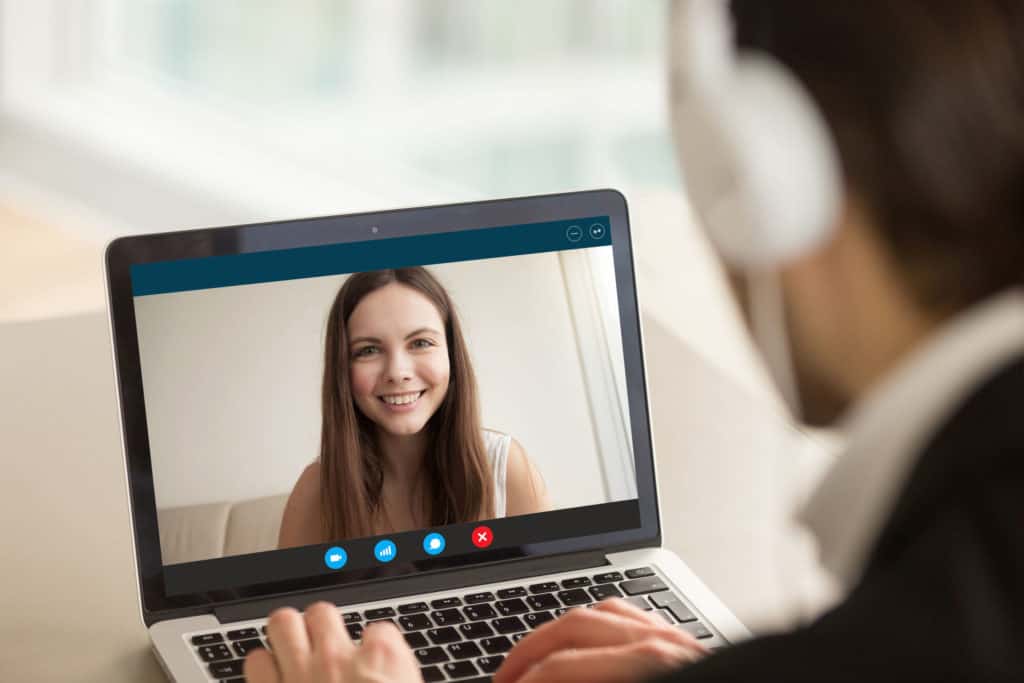 Eine Junge Frau und ein Personaler führen ein Bewerbungsgespräch online durch.