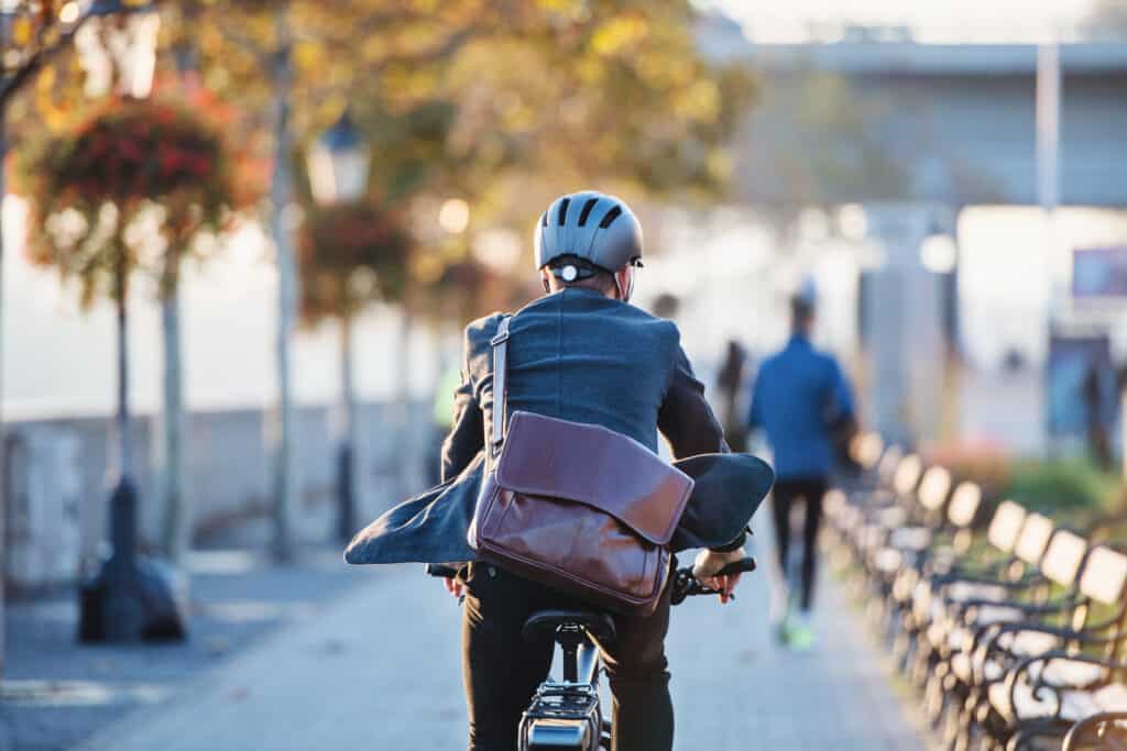 Junger Mann fährt mit dem E-Bike zu seiner Arbeit