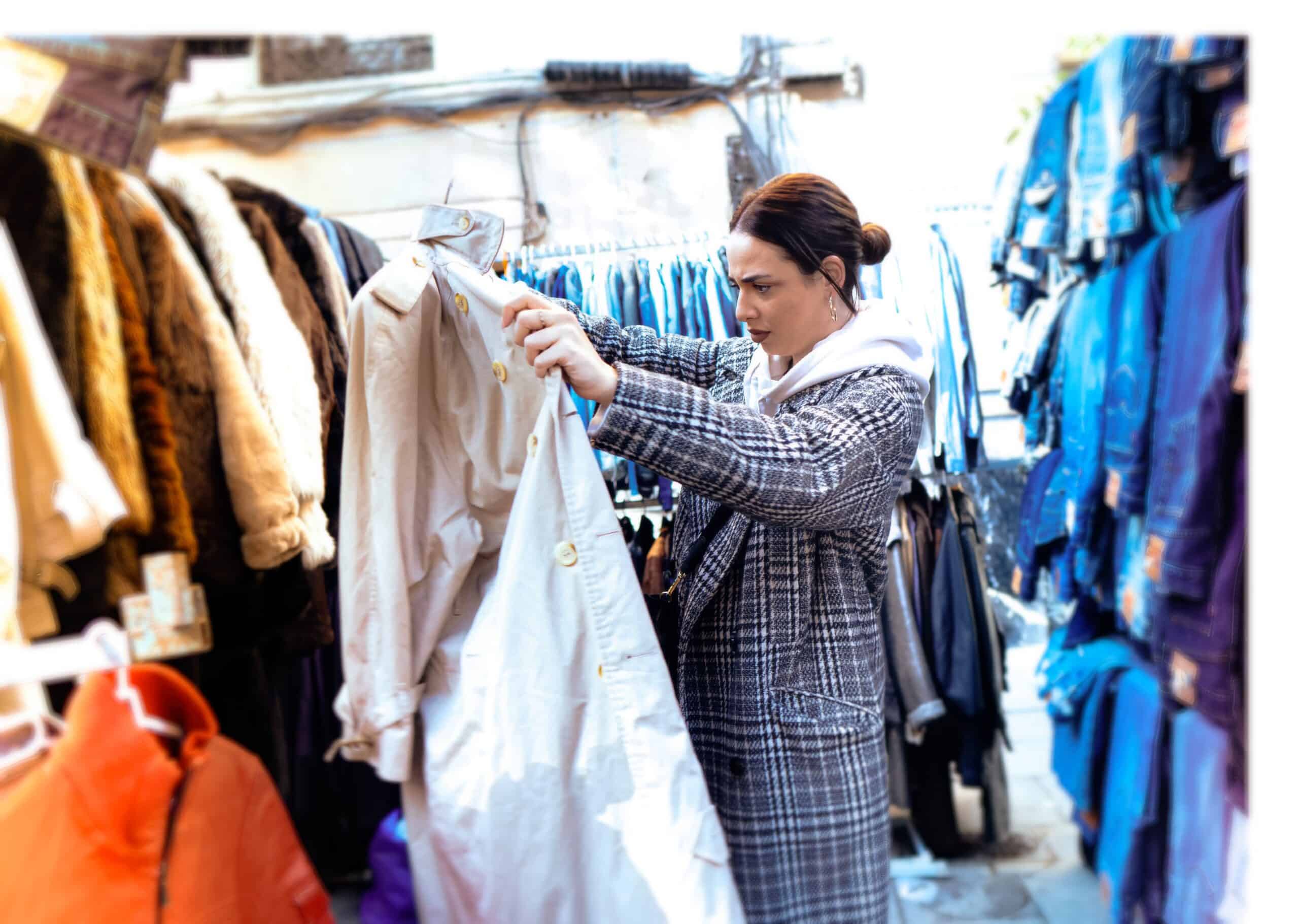 Frau sucht Klamotten auf Flohmarkt zum Reselling 