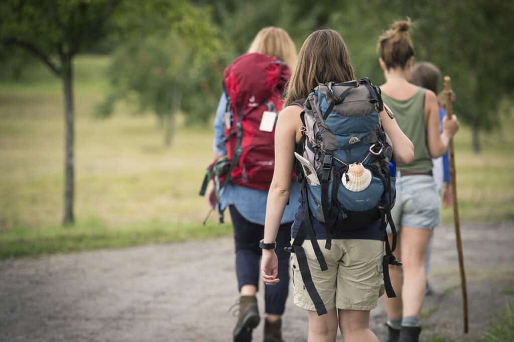 Pilgerwanderung, Menschen mit Rucksäcken auf dem Rücken