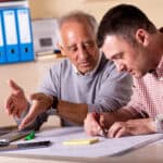 2 Männer verschiedener Generationen arbeiten zusammen an einem Projekt