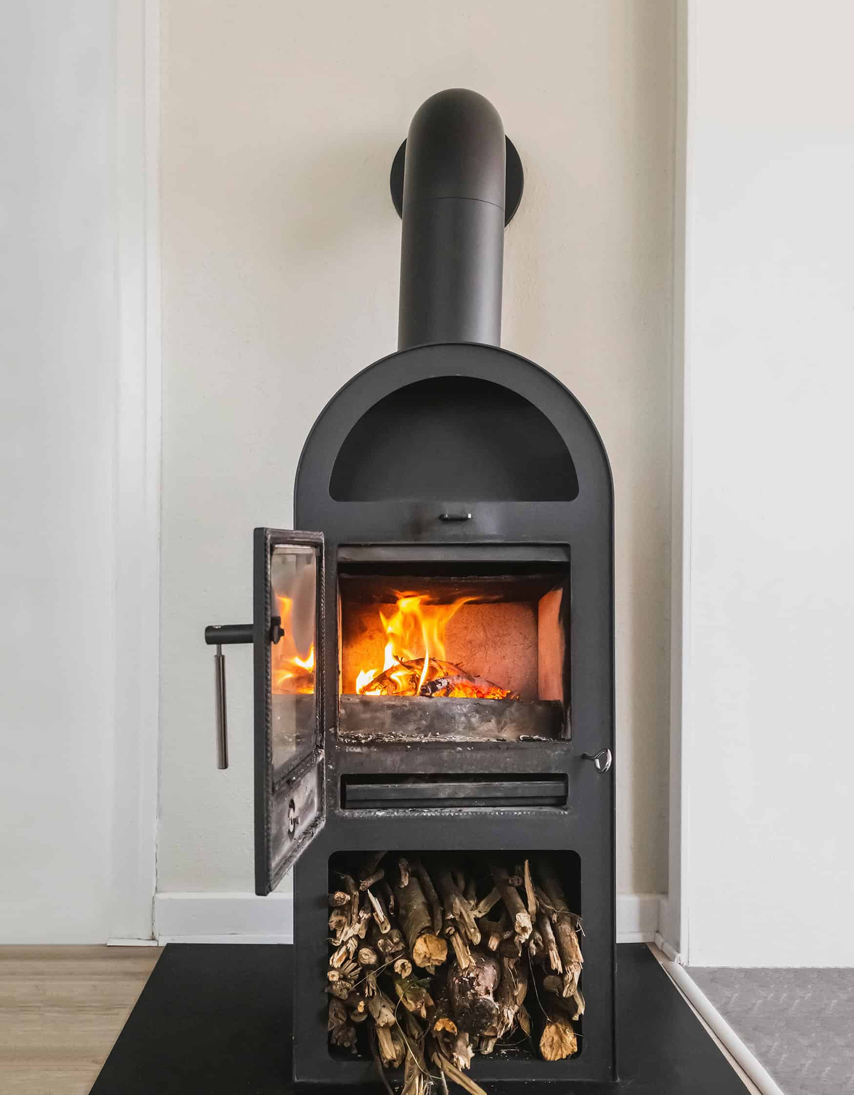 Kamine und Feuerstätten Das sollten Hausbesitzer wissen Kamine und Feuerstätten: ein Moderner brennender Kamin mit lagernden Holz.